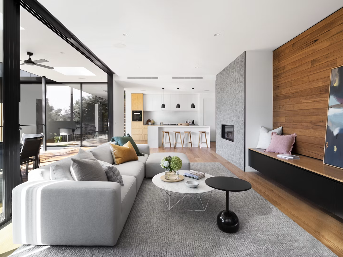 Open-plan living and kitchen area with timber feature wall and wide sliding doors